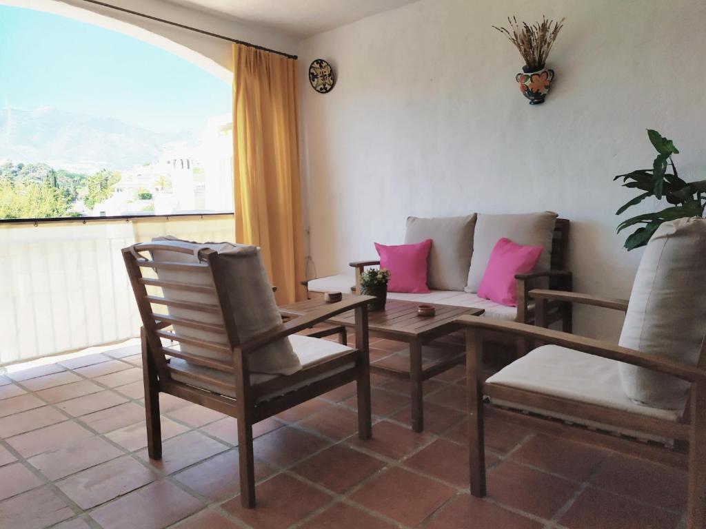 salon z kanapą, stołem i krzesłami w obiekcie holidays in pueblo evita w mieście Benalmádena