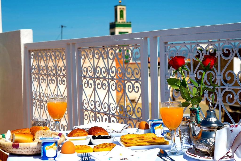 een tafel met eten en drinken op een balkon bij Riad Safir in Meknès