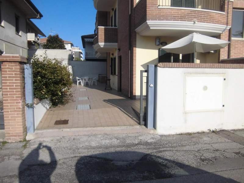 l'ombra di una persona con un ombrello accanto a un edificio di La casa di Giò ad Alba Adriatica