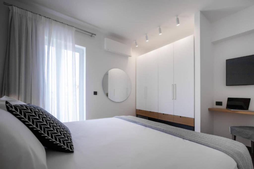 una camera con letto bianco e TV di The H Experience Boutique Apartment Koules Fortress Heraklion a Heraklion