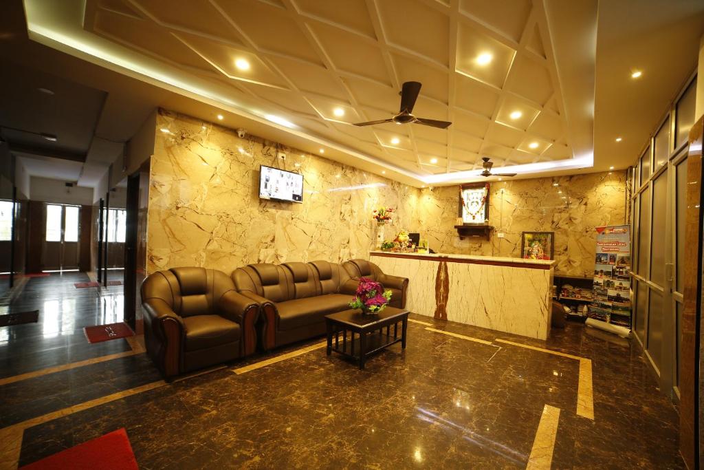 - un salon avec un canapé et une table dans l'établissement Hotel Ragavendra Rameswaram, à Rameswaram