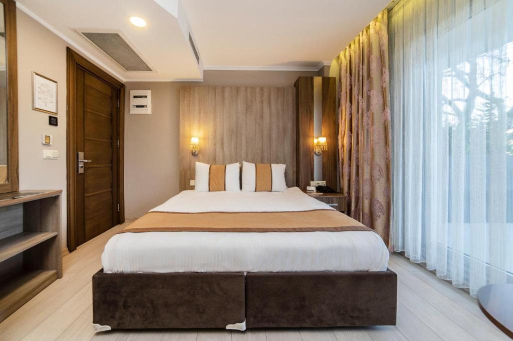 1 dormitorio con cama grande y ventana grande en Turk Inn Ferro Hotel, en Çekirge