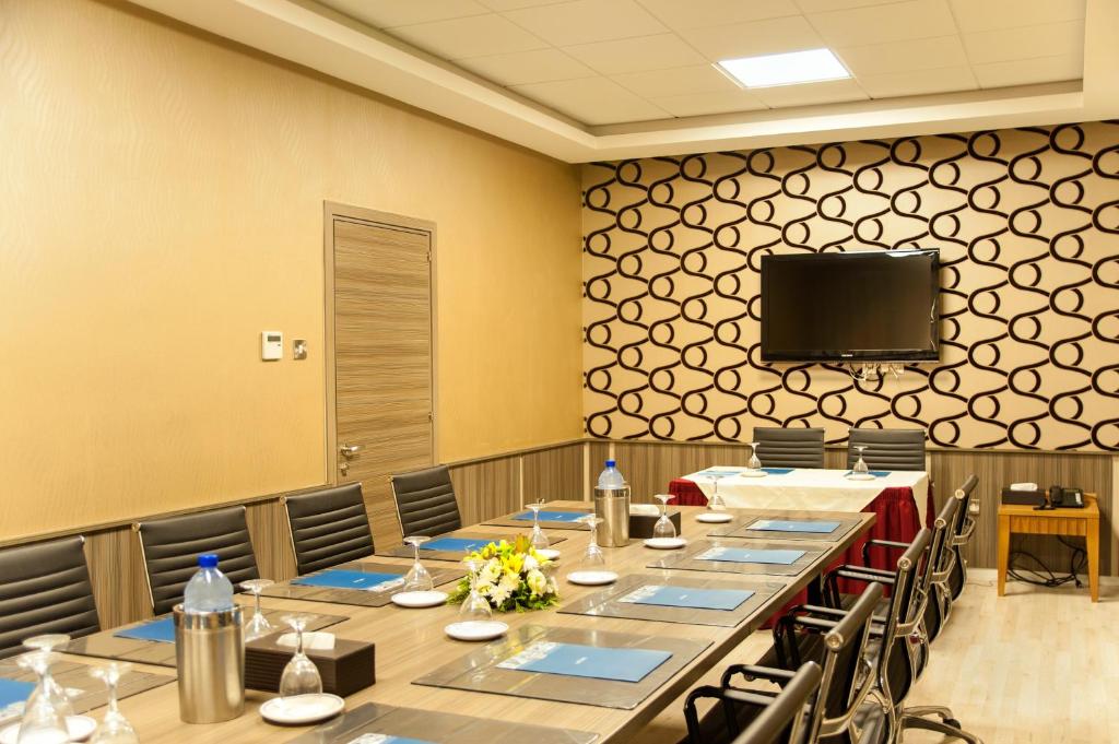 a conference room with long tables and a flat screen tv at Ajax Hotel in Limassol