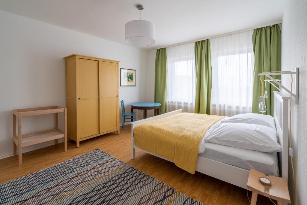a bedroom with a bed and a window with green curtains at Ferienwohnung Hochgefühl in Hohegeiß