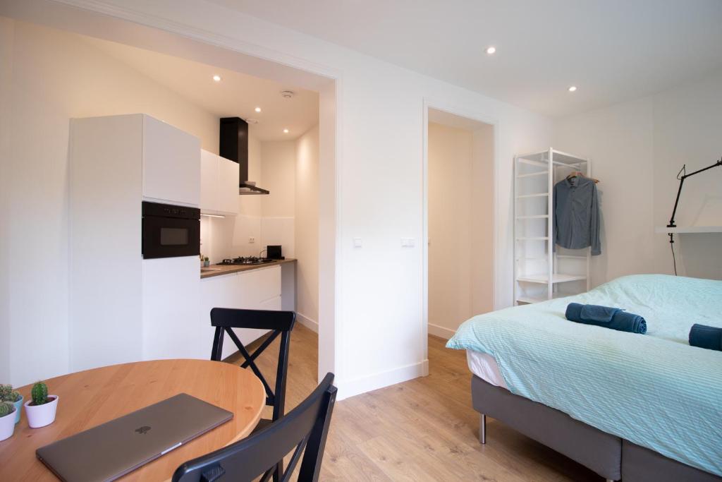 een kamer met een bed en een tafel met een laptop bij Escamp Apartments in Den Haag