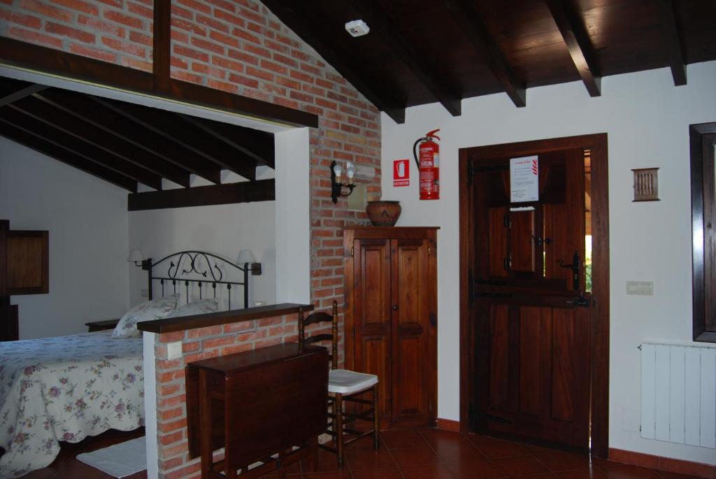 sypialnia z łóżkiem i ceglaną ścianą w obiekcie Apartamentos El Perujo w mieście Comillas