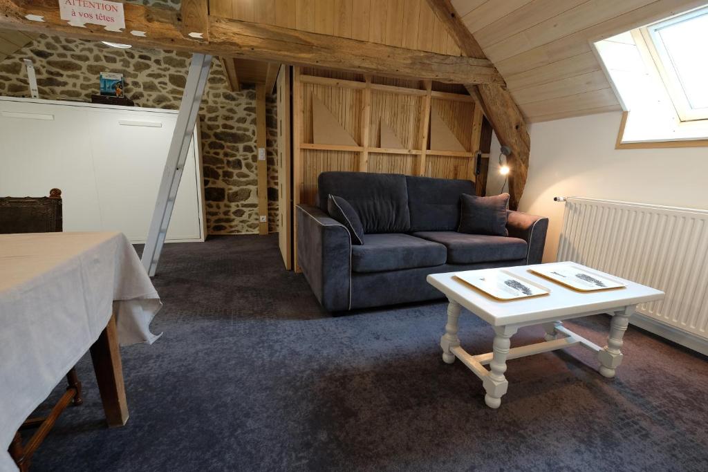 a living room with a couch and a table at Le Logis de Mordreuc in Pleudihen