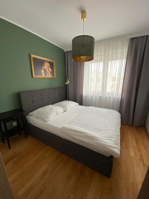 a bedroom with a large bed with white sheets at Apartament F&J #35 in Toruń