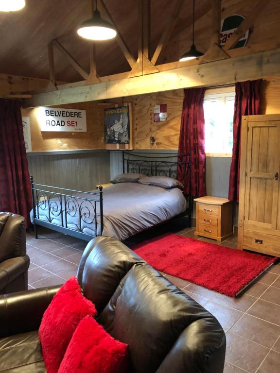 a bedroom with a bed and a leather couch at The Lodge in Bedford