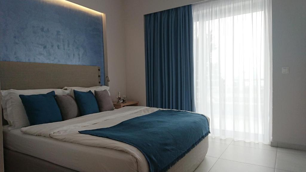 a bedroom with a large bed and a large window at Diolkos Studios in Loutraki