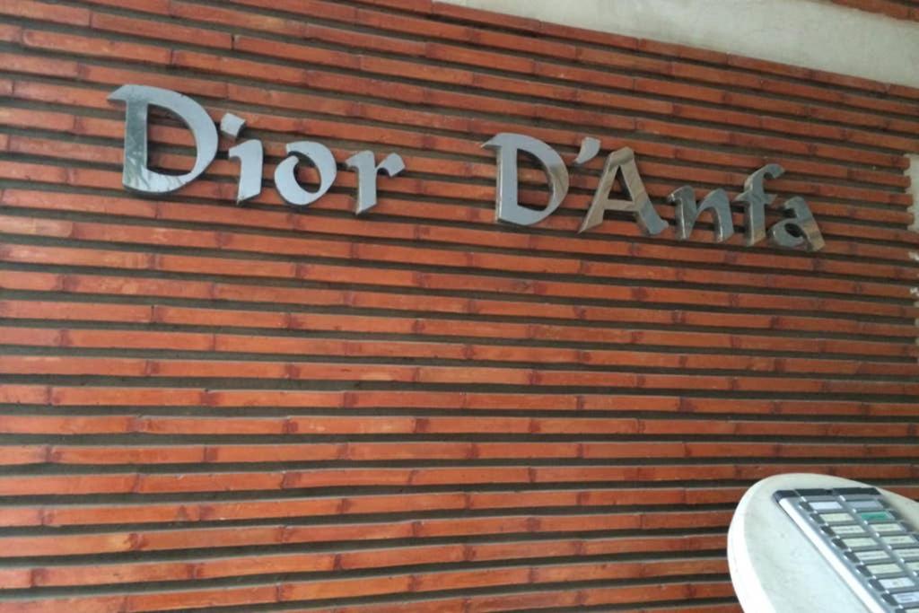 Una pared de ladrillos con un cartel que dice "lanza dardos" en Dior D'Anfa, en Casablanca