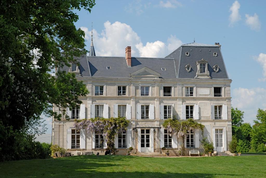 una gran casa blanca con un gran patio en Chambres d'Hotes Château de la Puisaye, en Verneuil d'Avre et d'Iton