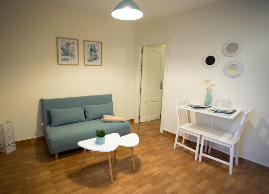 salon z kanapą i stołem w obiekcie Apartamento EntreCaminos w mieście Setenil