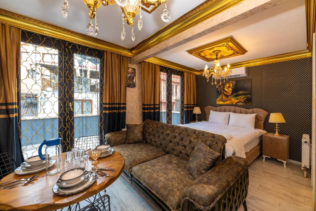 1 dormitorio con sofá, cama y mesa en By Mesut Residence - Taksim Cihangir en Estambul