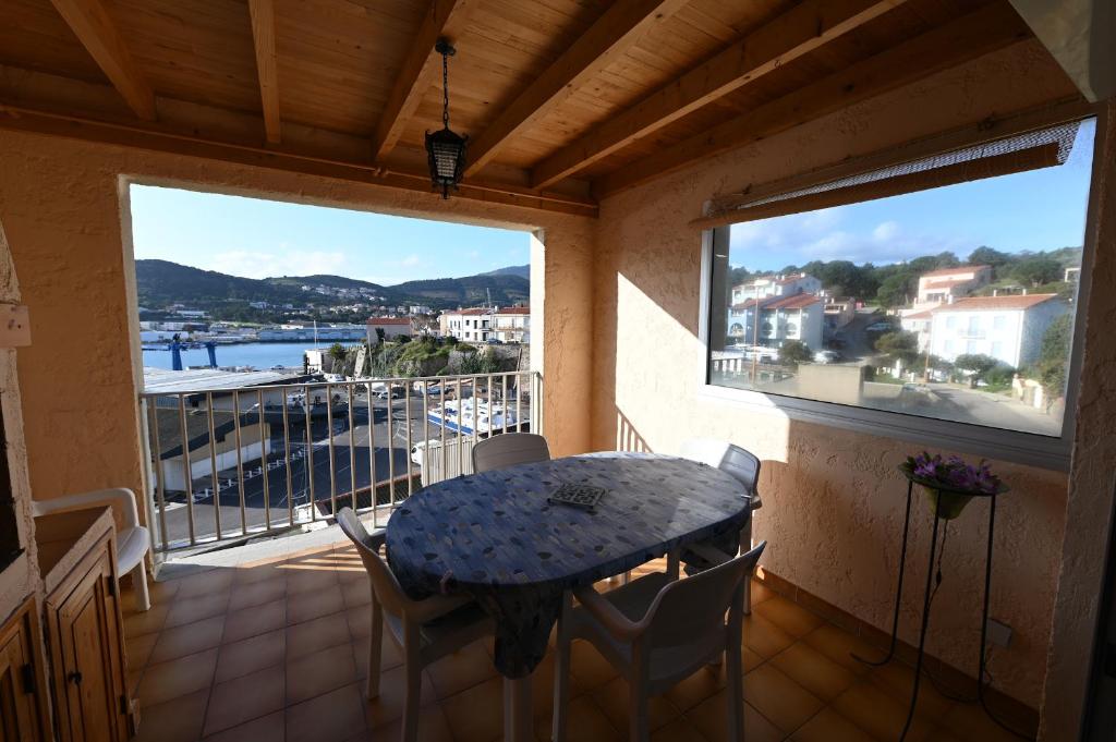 d'un balcon avec une table et des chaises et une vue sur l'eau. dans l'établissement superbe duplex bord de mer, à Port-Vendres