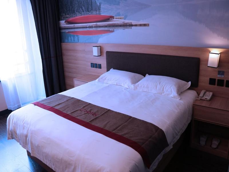 Cama en habitación de hotel con cama blanca grande en Thank Inn Chain Hotel anhui anqing yixiu district seven street wenyuan family, en Anqing