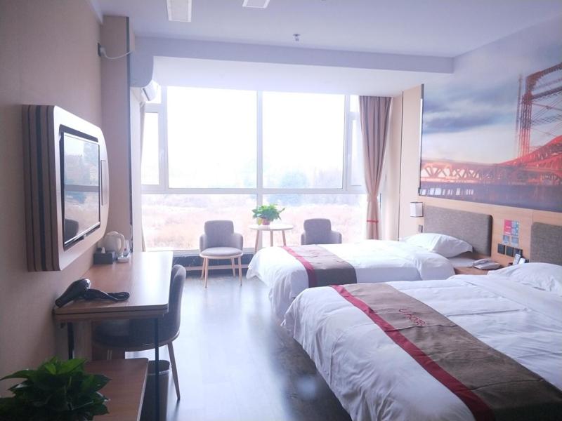 a hotel room with two beds and a large window at Thank Inn Chain Hotel hebei handan development zone high-speed railway station in Handan