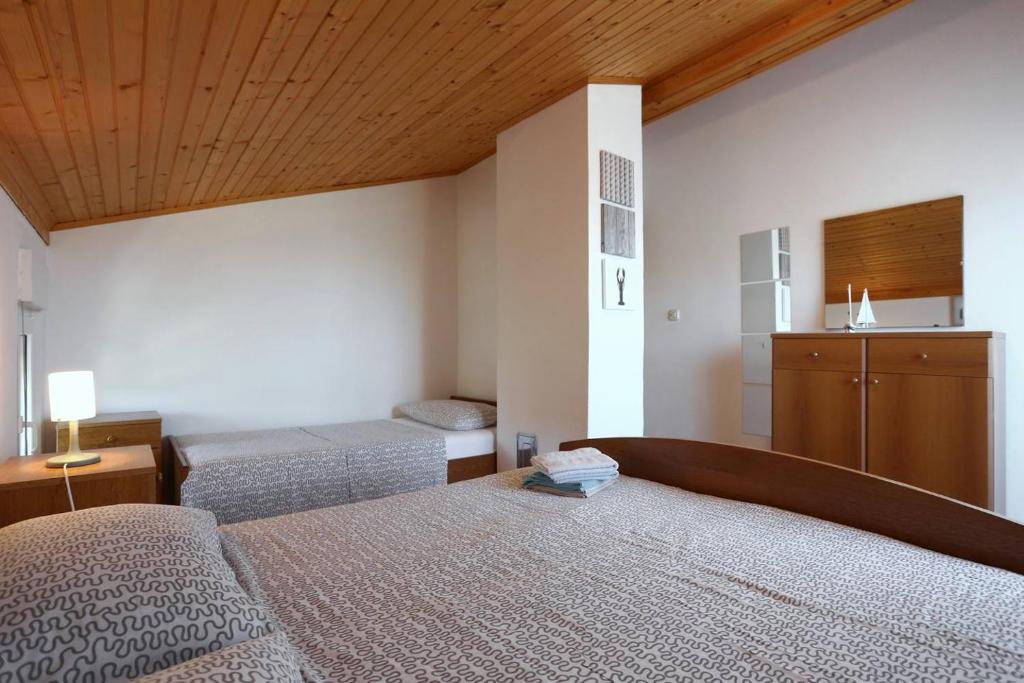 a bedroom with two beds and a wooden ceiling at Little Heaven on Earth - Apartmani Martina in Vlašići