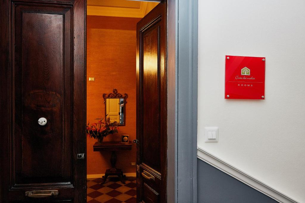 a hallway with a door to a bathroom with a mirror at Corte dei medici - Palace in Catania