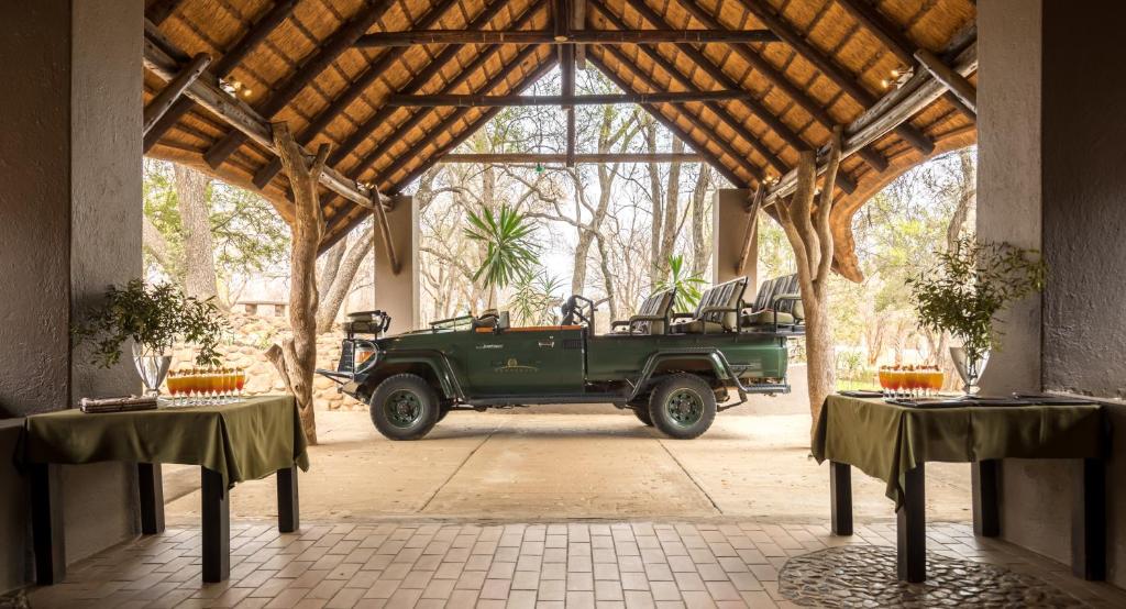 un jeep verde estacionado en un pabellón con mesas en Karongwe Portfolio- Shiduli Private Game Lodge, en Karongwe Game Reserve