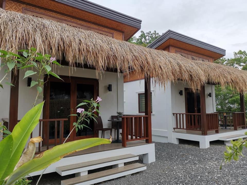 a cottage with a thatched roof and a patio at Alona Vikings Lodge 1 in Panglao