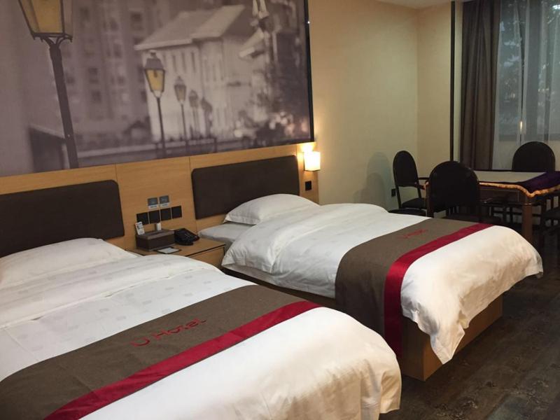 a hotel room with two beds and a table at Thank Inn Chain Hotel guizhou zunyi chishui city red army avenue jinshui bay in Chishui