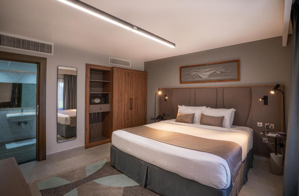 - une chambre avec un grand lit et une salle de bains dans l'établissement Marbella Resort, à Charjah