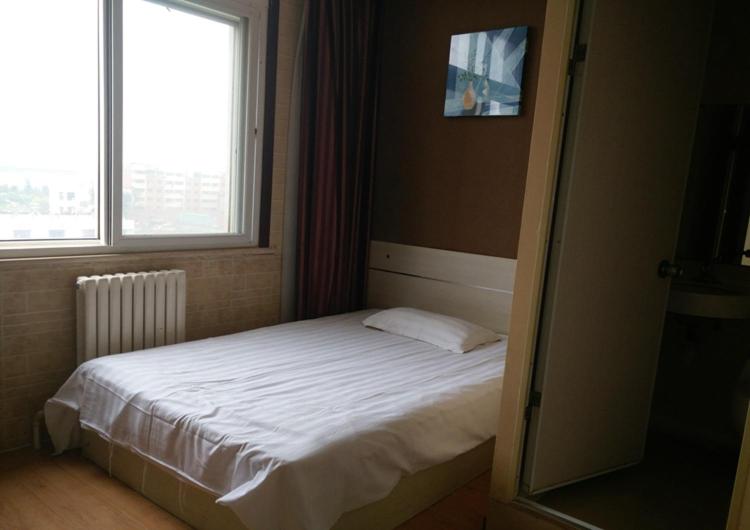 En eller flere senge i et værelse på Thank Inn Chain Hotel Shandong Qingdao huangdao chongming island road