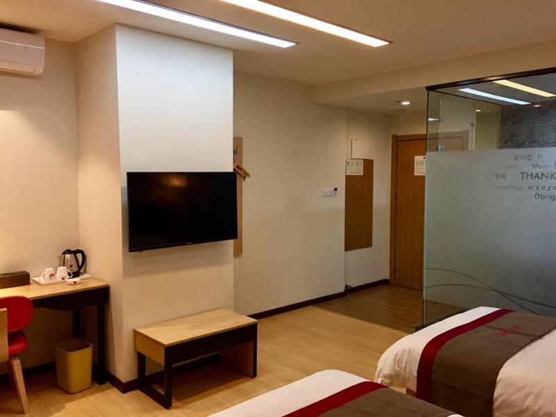 泉州市にあるThank Inn Chain Hotel fujian quanzhou fengze district donghai streetのベッド2台、薄型テレビが備わるホテルルームです。