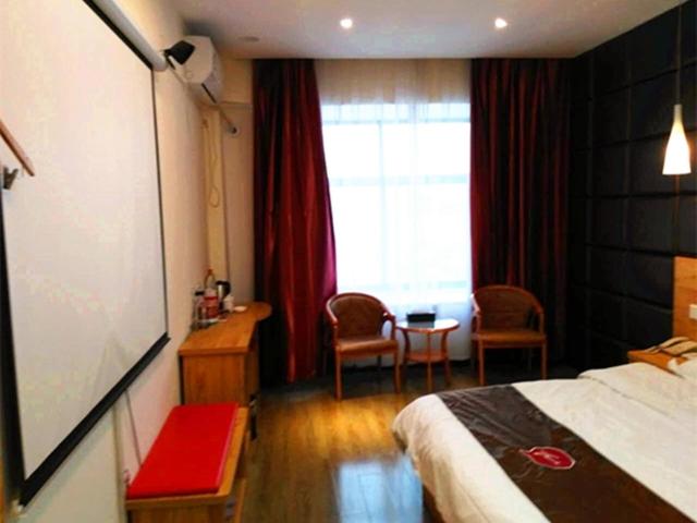 a hotel room with a bed and a window at Thank Inn Chain Hotel henan zhengzhou fangte green expo park in Zhengzhou