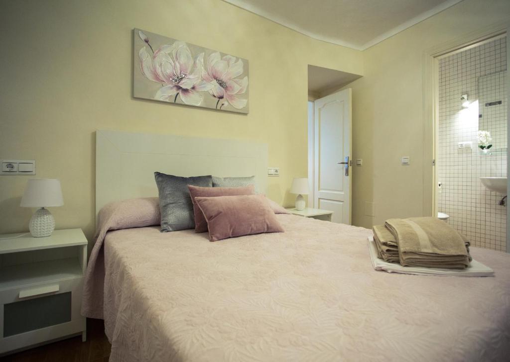 sypialnia z dużym łóżkiem z różowymi kwiatami w obiekcie Apartamento EntreCaminos w mieście Setenil
