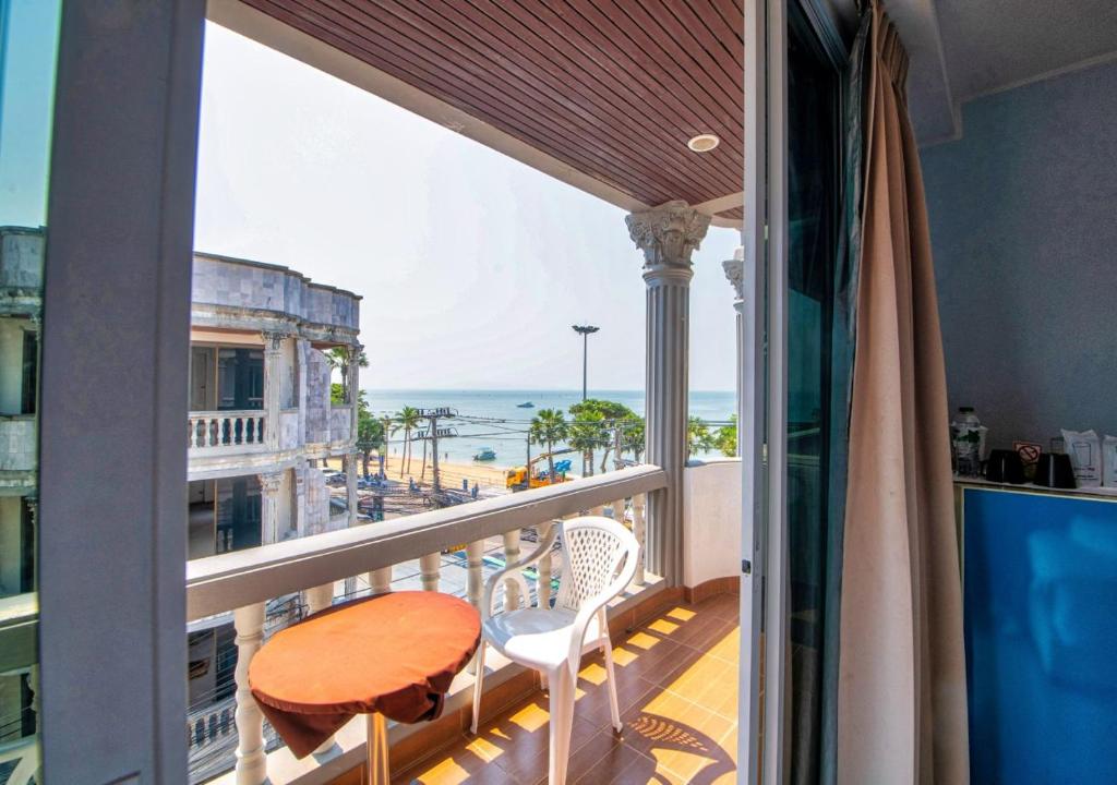 a balcony with a table and chairs and the ocean at Akvavit Living in Jomtien Beach