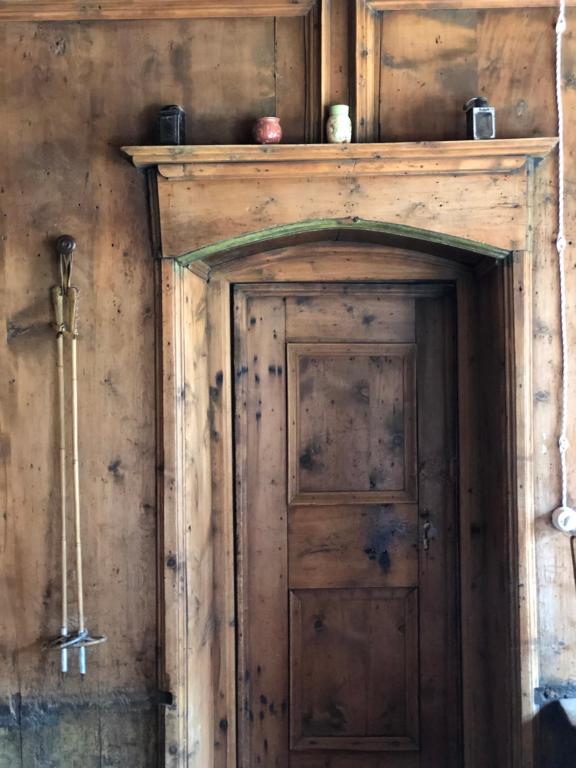 eine alte Holztür in einer Holzwand in der Unterkunft AgroPobitzer in Mals im Vinschgau