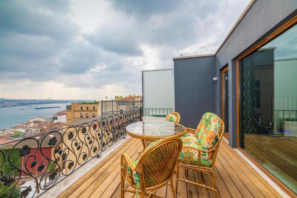 ein Balkon mit Tisch und Stühlen und Blick auf das Wasser in der Unterkunft Istanbul Taksim Residence Hotel By MESUT in Istanbul