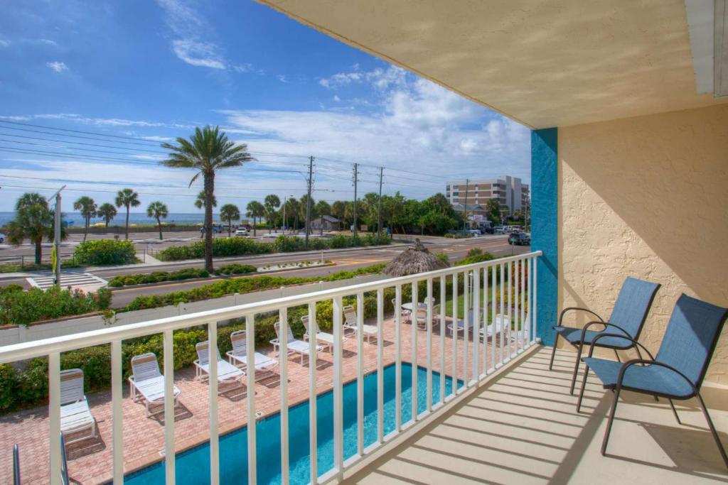 a balcony with chairs and a swimming pool at 103 - La Coquina in St Pete Beach