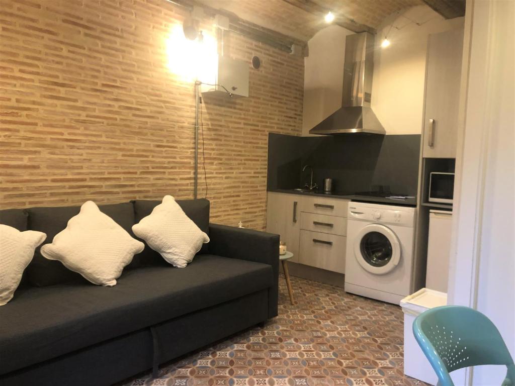 ein Wohnzimmer mit einem Sofa und einer Waschmaschine in der Unterkunft Tetuan Silence in Valencia