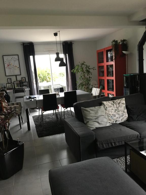 a living room with a couch and a table at chambres chez Brigitte et Patrick près du Mont st Michel in Saint-Quentin-sur-le-Homme