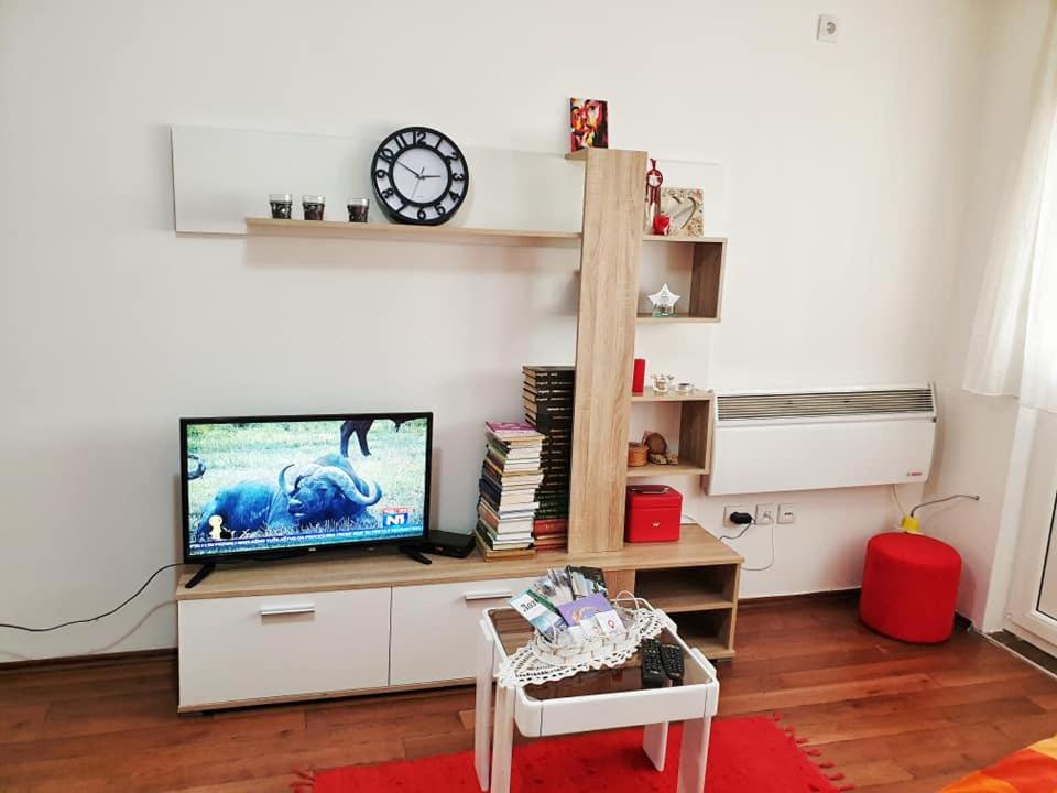 Stan na dan Loznica في لوزنيكا: غرفة معيشة مع تلفزيون وساعة على الحائط