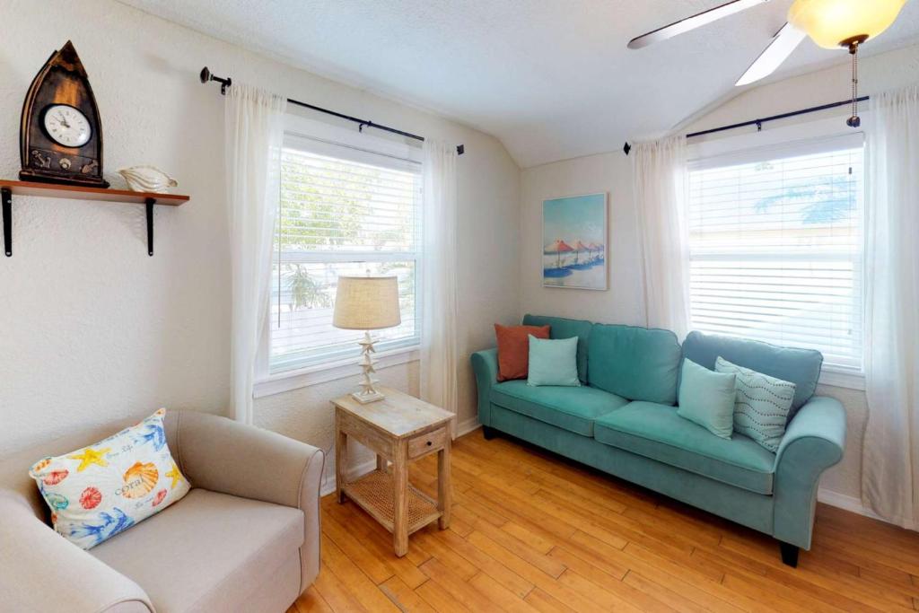 uma sala de estar com dois sofás azuis e uma mesa em 103 - Sea Cottage em St. Pete Beach