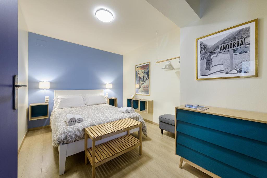 Habitación pequeña con cama y pared azul en Apartamento Escapada, en Andorra la Vella