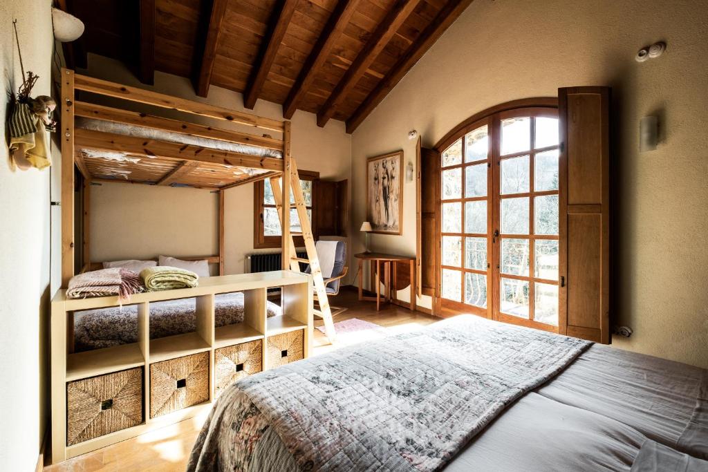 a bedroom with two bunk beds and a window at Mas La Cabanya Beget Xalet de muntanya in Beget