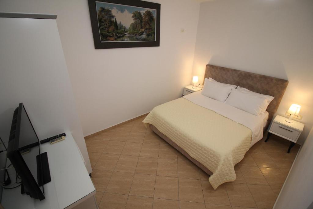 a small bedroom with a bed and two night stands at Julia Hotel in Sarandë