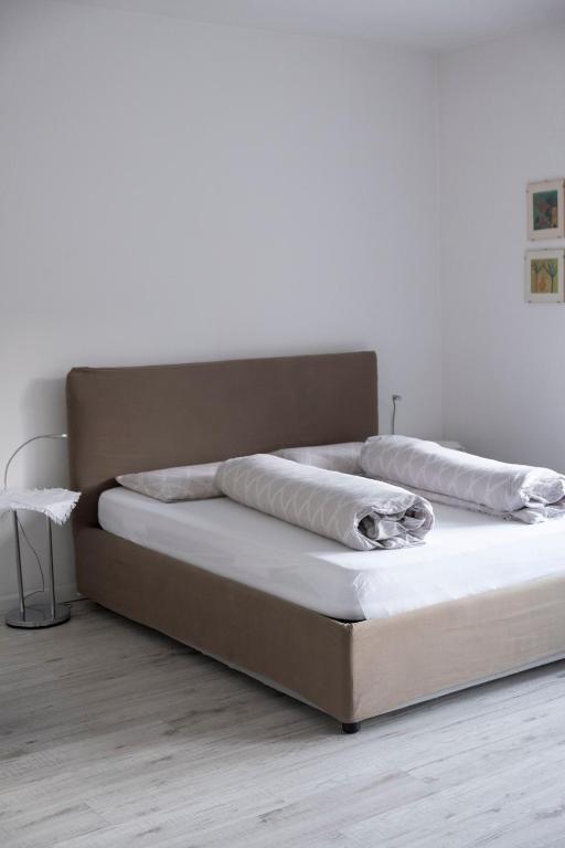 łóżko z dwiema poduszkami na górze w obiekcie City Apartments Portico w Meranie