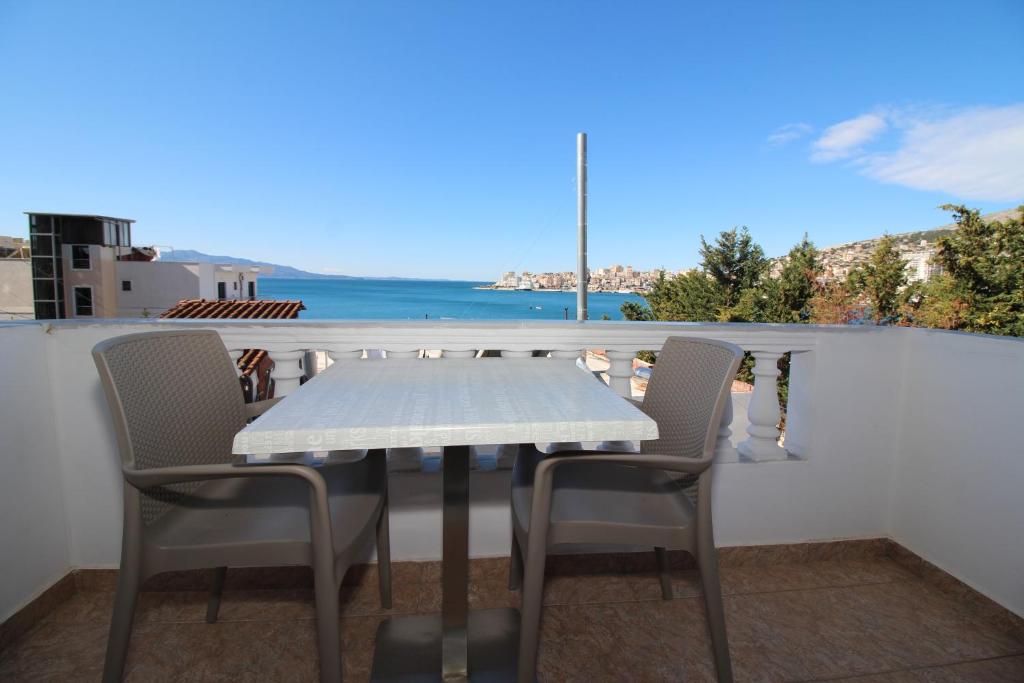 a table and chairs on a balcony with a view of the ocean at Julia Hotel in Sarandë
