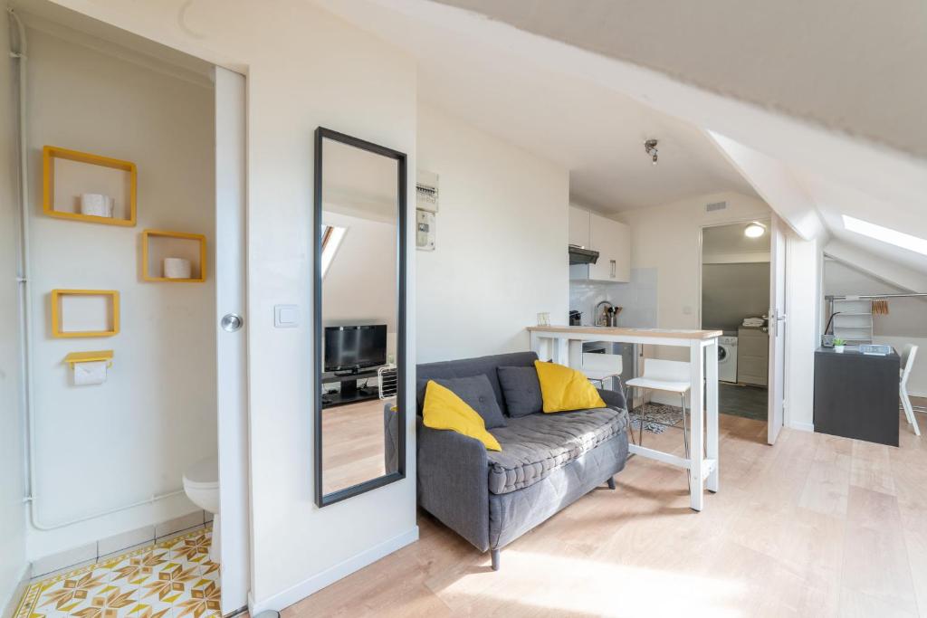 un salon avec un canapé et une table dans l'établissement APARTEO - Stade de France 15min - Parc des expositions - Paris 17min, à Aulnay-sous-Bois