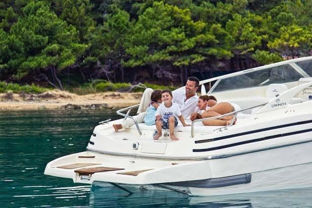 a man and two children sitting on a boat in the water at Ionian View Yachts in Zakynthos
