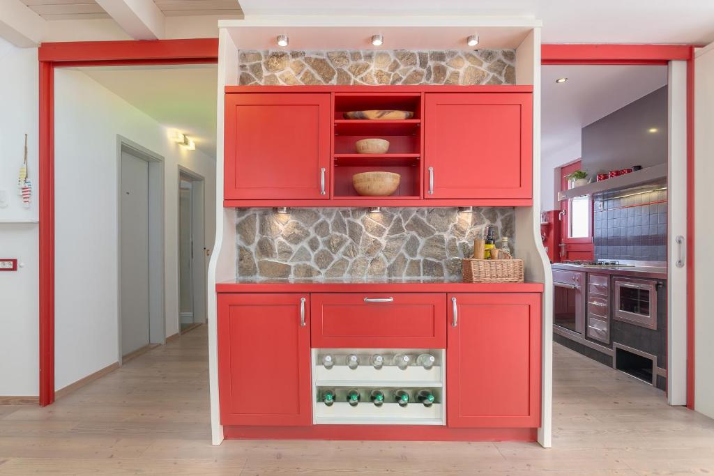 un armario rojo en una cocina con rocas. en Apartma Natura, en Bled