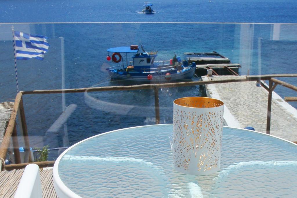 a table with a vase on top of a table with a boat at Afrodite Luxury Rooms in Kalymnos