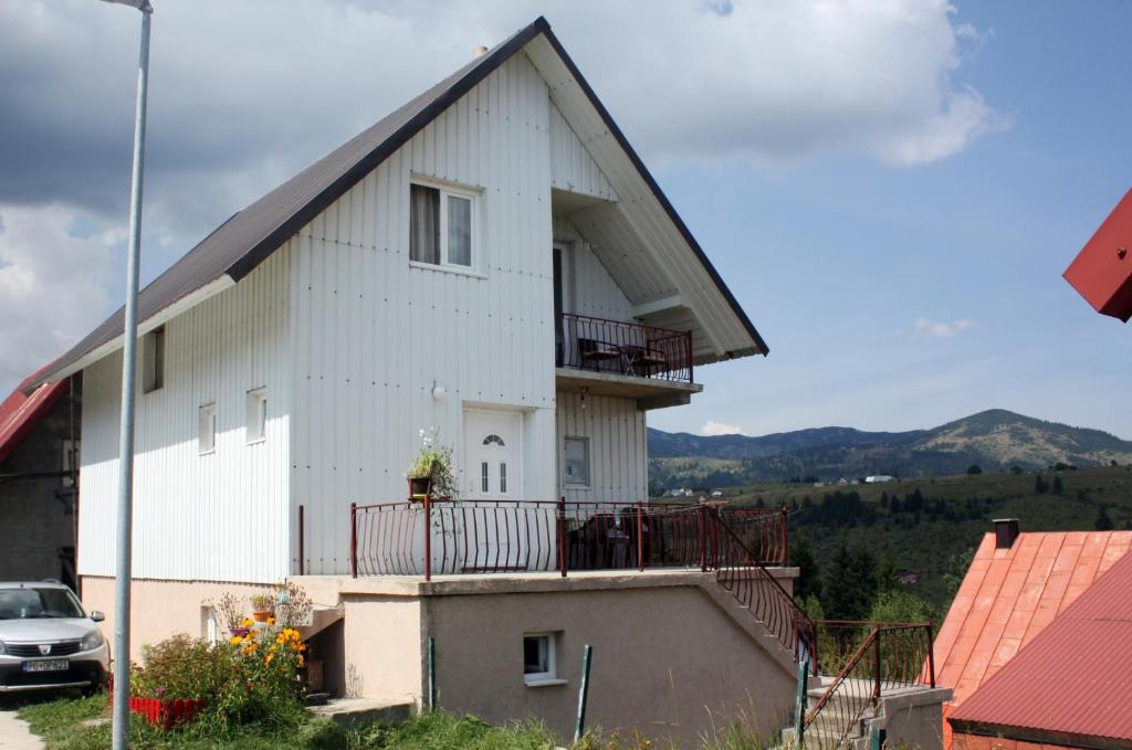 a white building with a balcony on top of it at Apartment Ruzica in Žabljak
