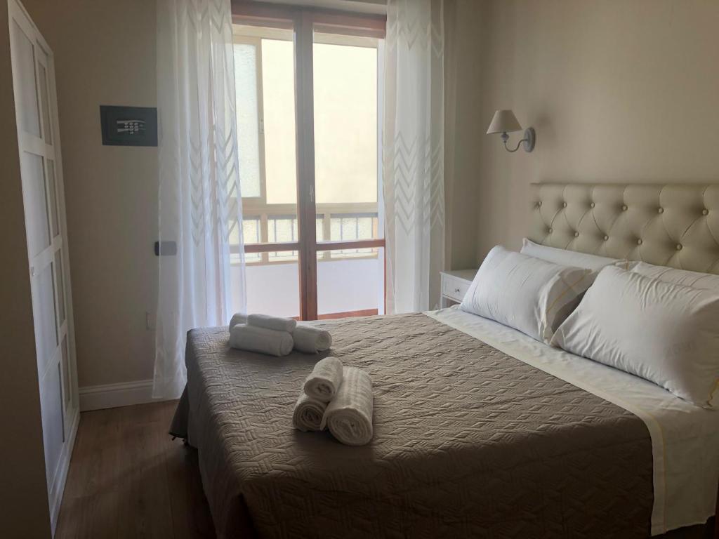 sypialnia z dużym łóżkiem z ręcznikami w obiekcie GISELLE HOUSE w Cagliari